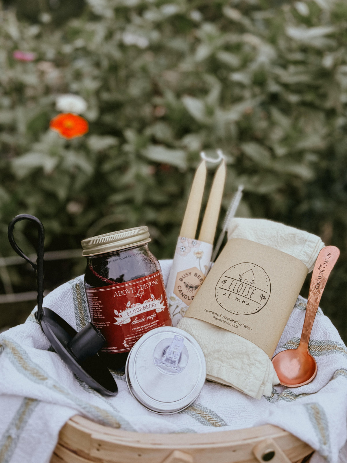 Heirloom gift bundle featuring elderberry syrup, two tapered beeswax candles, tea towel, copper spoon, cast iron candle holder and pouring spout