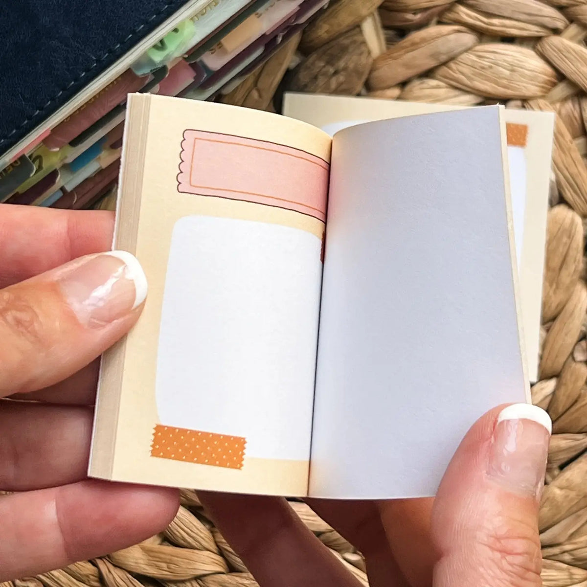 Small, sticky notepad with colorful design held by a hand on a woven surface