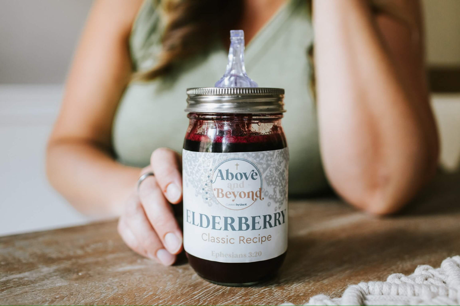 Lisa K and her best elderberry syrup recipe with immune-boosting properties, featuring a mason jar pour spout