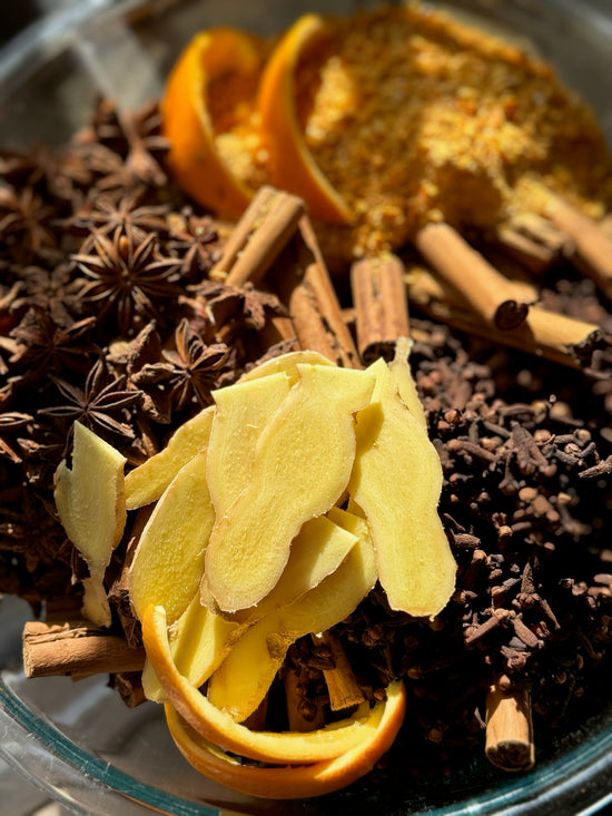 Here's a bowl of how we make the best elderberry syrup recipe - by infusing 100% organic, whole ingredients (ginger, raw honey, maple syrup, clove, Ceylon cinnamon sticks, lemon juice, whole star anise, and grated orange peel). 