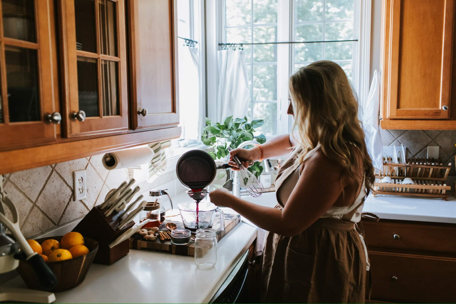 Lisa K. straining the best elderberry syrup recipe for boosting your immune system