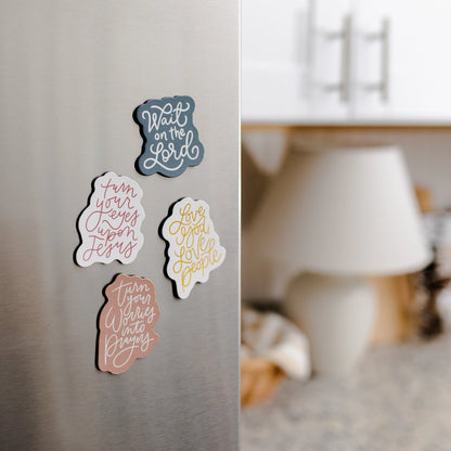 Decorative magnets with Christian inspirational phrases on a refrigerator door.