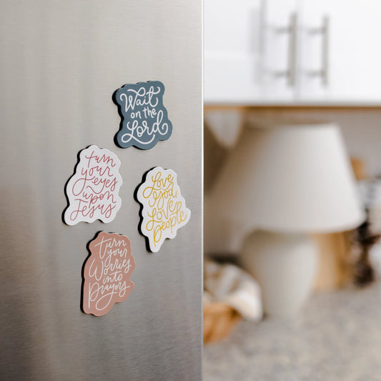 Decorative magnets with Christian inspirational phrases on a refrigerator door.