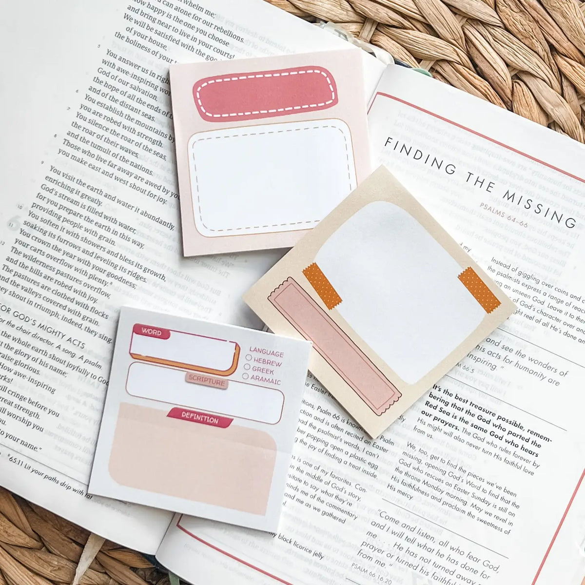 Note-taking accessories on an open book with a woven surface background